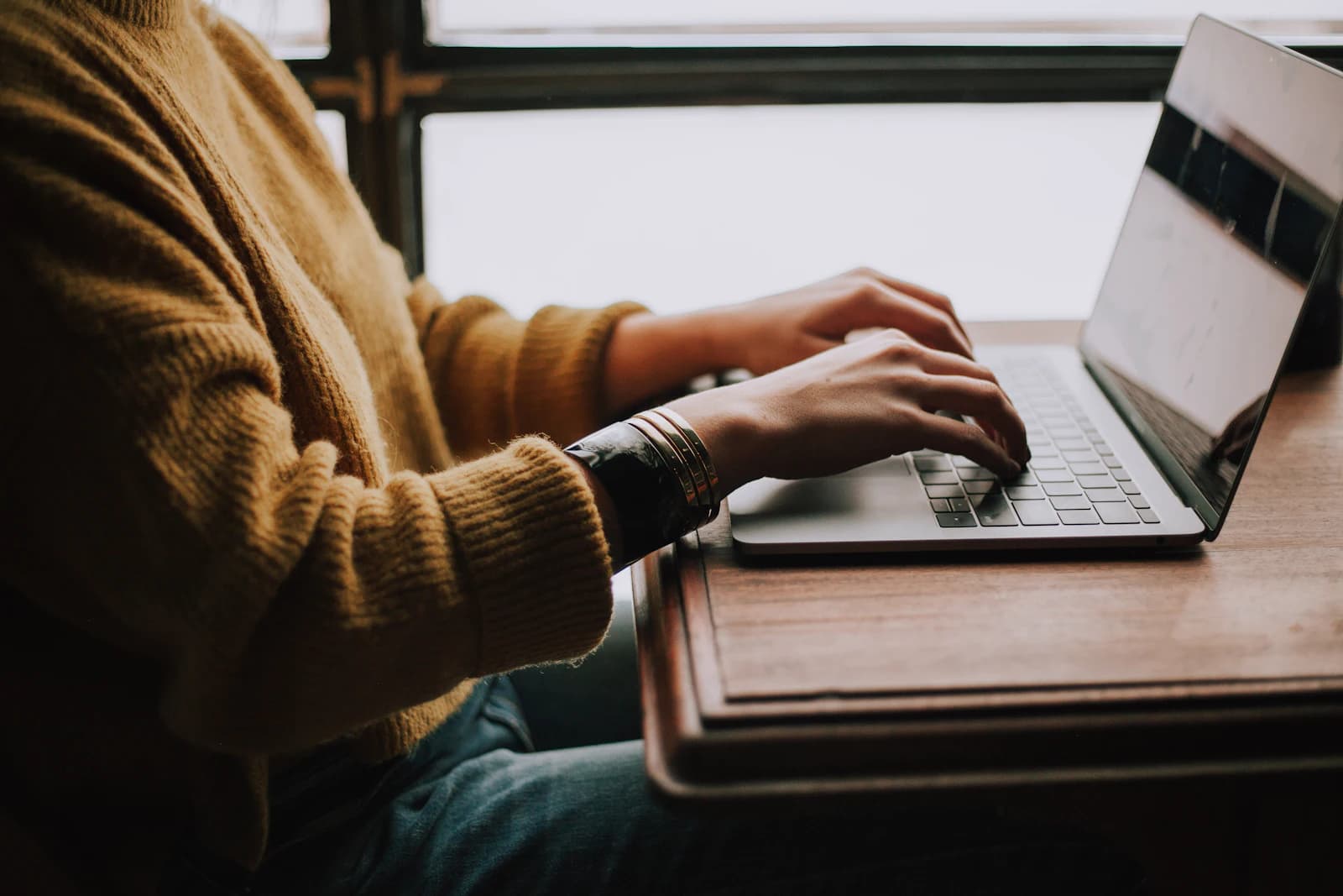 A person working alone at a laptop in a quiet room